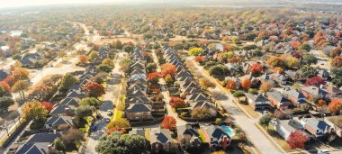 Dallas 'taki Panorama göl kıyısında yeni iki katlı tek katlı aile evleri rengarenk sonbahar yeşillikleri. Yerel cadde boyunca parlak turuncu renk ve yol, güzel Teksas sonbahar sahnesi