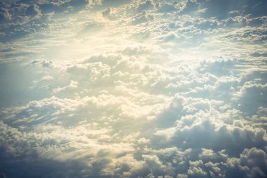 Gün doğumunda uçak penceresinden görülen güzel ve sıradışı Altocumulus veya Cirrocumulus bulut oluşumu. Havadan bulutların üzerinde ufuk çizgisi görünümü