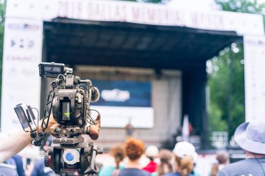 Dallas, Texas, Usa 'daki halk parkında bulanık seyirci geçmişi olan el yapımı profesyonel kamera kaydı. Dış monitörlü video kamera ve stereo mikrofonu iptal eden gürültü