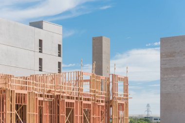 Çok katlı otopark ve asansör şaftı ile yapım aşamasında lüks multistory condominium bina. Apartman kompleksi ve beton taşıma altyapısının ahşap çerçeve kiriş kirişleri