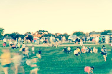 Vintage sesi soyut farklı insanların büyük bir grup bulanık Dallas, Teksas, Amerika yakınlarındaki kentsel parkta yaz etkinliğe katılmak. Aile üyeleri grubu bokeh aydınlatma ile gün batımında kamu festival keyfini çıkarın