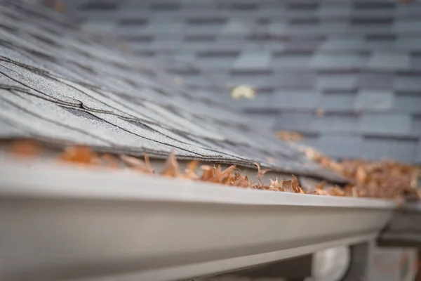 乾燥葉の完全な住宅の屋根の帯状疱疹の近くに選択的な焦点を詰めガッタや汚れの必要性をクリーンアップします 屋上のブロックされた排水管 ガタークリーニングとホームメンテナンスの概念 — ストック写真