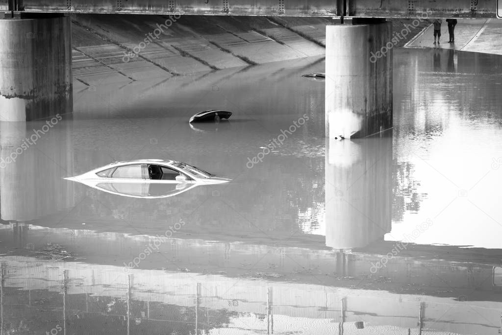Top view swamped car under a tollway bridge near downtown Houston, Texas. Two sedan flooded under elevated highway road by heavy rain hurricane.