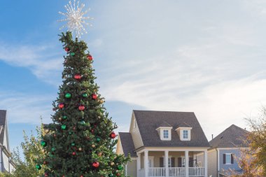 Kar tanesi ağacının tepesi ve renkli cam süslemelerle dolu devasa Noel ağacı ABD 'nin Coppell kentindeki City Square' de sergileniyor. Dallas yakınlarındaki köy tarzı evlerin Noel süslemeleri.