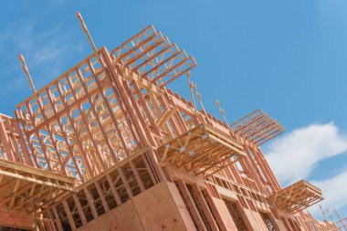 Kuzey Dallas, Teksas, Amerika yakınlarında yapım aşamasında büyük veranda ile modern condominium binanın düşük açı görünümü. Ahşap çerçeveli ahşap ev, kiriş, joist, bulut mavi gökyüzü altında kiriş yakın çekim