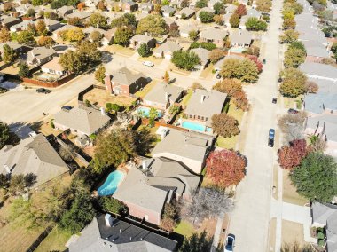 Dallas 'ın banliyölerinde renkli sonbahar yeşillikleri olan lüks havuz evleri manzarası. Geniş bağımsız ev daimi konut, yeni çatı kiremitleri, solda bir cul-de-sac (çıkmaz sokak)