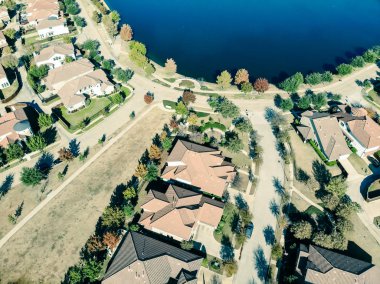 Güneşli bir sonbahar gününde, Dallas yakınlarında renkli yapraklarla yeni göl manzaralı bir apartman dairesi. Ahşap çitli arka bahçeli ve manzaralı tek aile evleri.