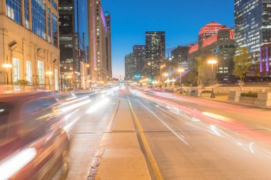 Akşam saatlerinde Chicago şehir merkezindeki Wacker Dr caddesinde yoğun trafik. Silüeti, gökdelen binaları ve mavi saat, alacakaranlıkta ışık parkurları güzel modern cityscape görünümü.