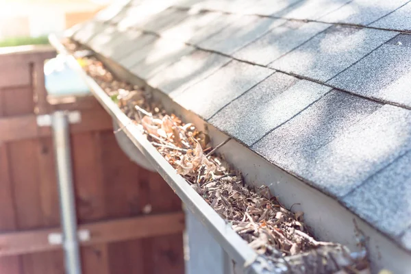 盖特附近的屋顶瓦片的住宅充满了干燥的叶子和肮脏的需要清理 水沟清洁和家庭维护概念 — 图库照片