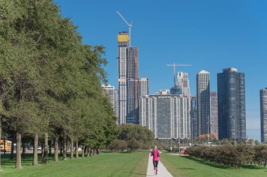 Michigan Gölü boyunca Chicago şehir parkında çalışan fitness bayan arka görünümü. Gündüz sonbahar spor egzersiz sağlıklı kadın