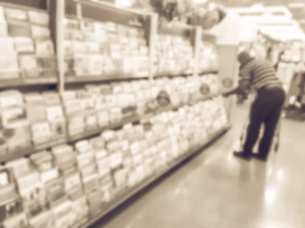 Filtered image blurry background customer selecting greeting cards display at a supermarket in USA