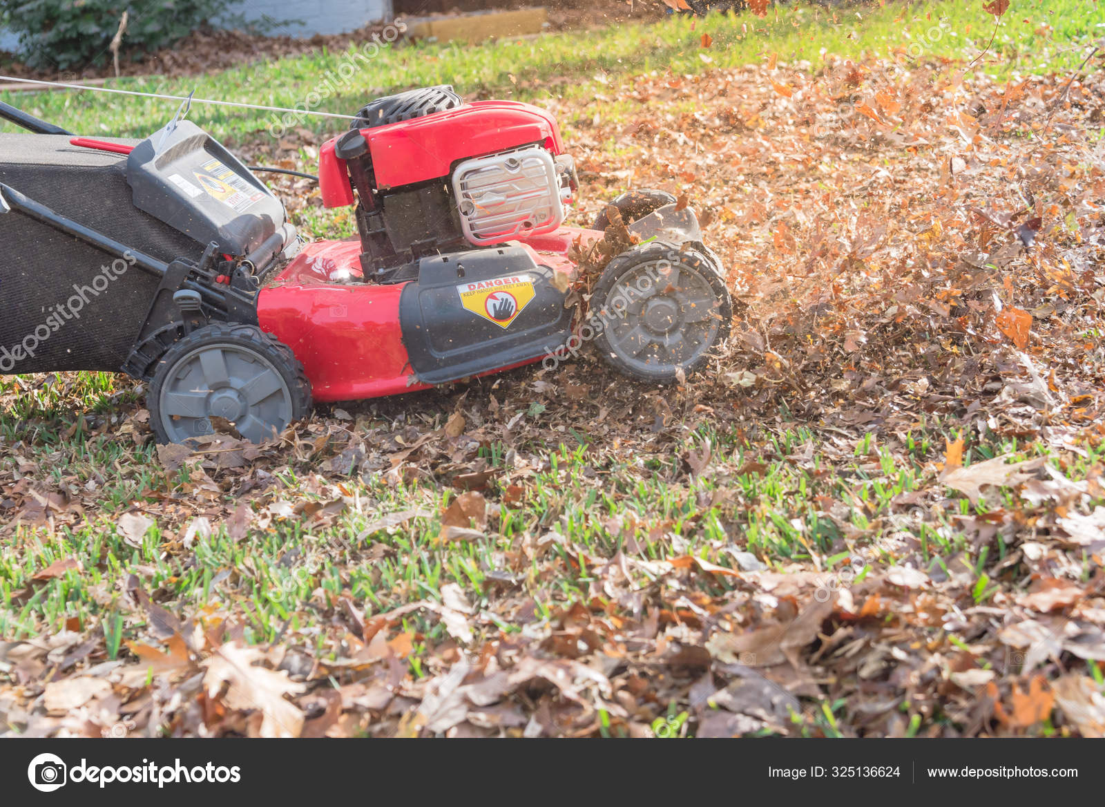 Working lawn mower mulching autumn leaves for lawn care in Texas, USA