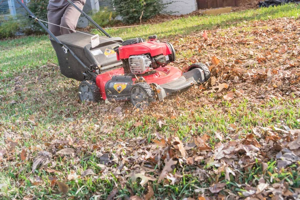 Lawn mower mulching autumn leaves near utility flag lawn care in Texas, USA — Stock Photo, Image
