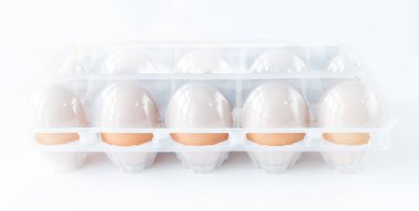 Stüdyo çekimi kapalı plastik tepsi ile on otlatılmış kızarmış tavuk yumurtası beyaz üzerinde izole