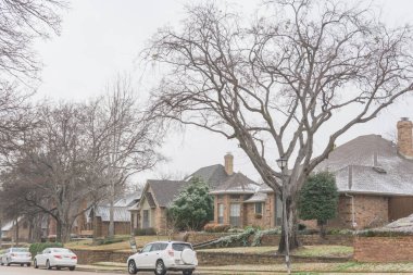 Tipik bungalov evi ve Dallas yakınlarındaki kar altında park edilmiş arabalar.