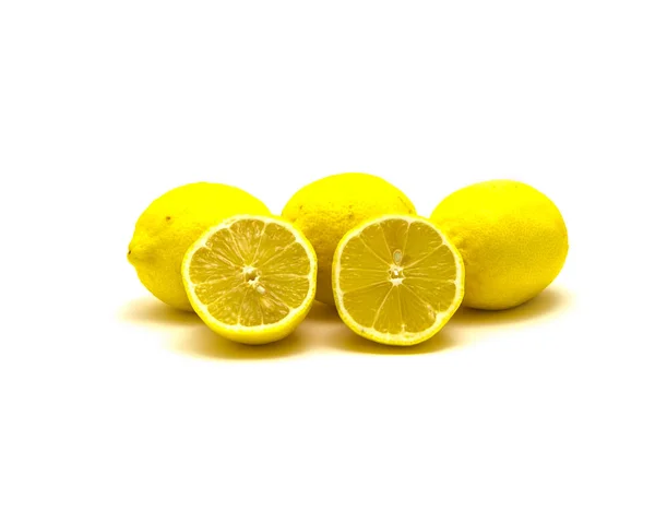 Studio shot pile of organic raw lemons with slice cuts isolated on white — Stockfoto