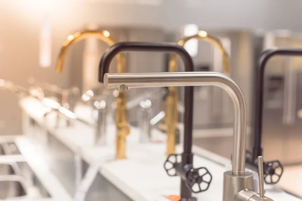 Selective focus of shiny faucets with pull out sprout and price tag at furniture showroom in Texas, USA — Stok fotoğraf