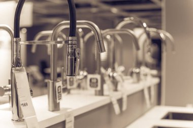 Metal kitchen faucets and sinks on display at furniture showroom in Texas, USA