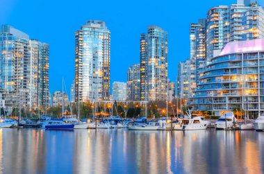 Gökdelenler mavi saatte Vancouver Bc 'daki False Creek nehri boyunca yansıyor.