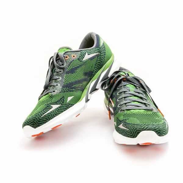 Green and orange running shoes with laces isolated on white studio shot — ストック写真