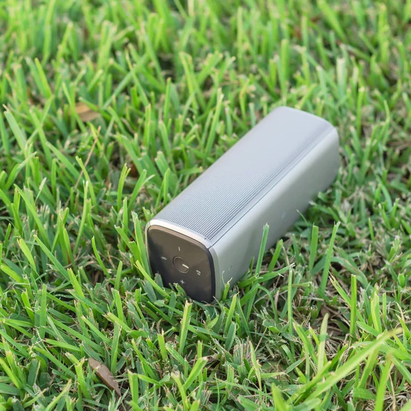 Top View šedý Bluetooth reproduktor na zeleném trávníkovém parku při západu slunce — Stock fotografie