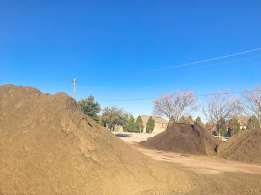 Large heap of organic topsoil pile at wholesale compost plant near Dallas, Texas clipart
