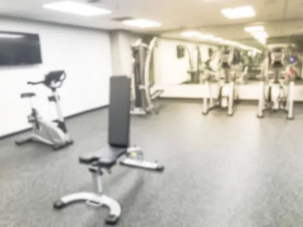 Blurry background treadmill, elliptical, strider and workout equipments at modern fitness center in USA — Stock Photo, Image