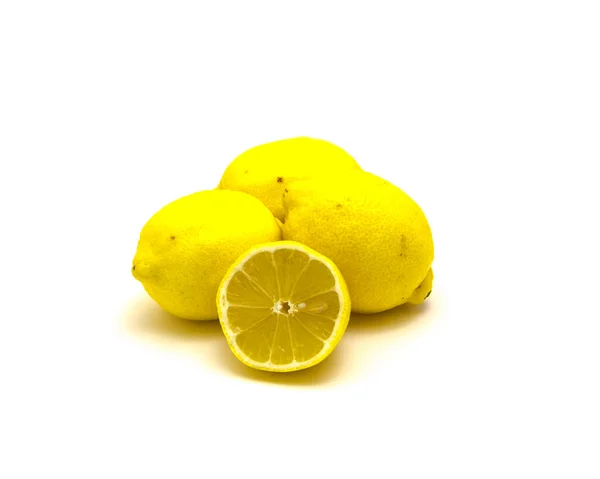 Studio shot pile of organic raw lemons with slice cuts isolated on white — Stockfoto