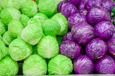 Kırmızı ve yeşil lahana kafalar Puyallup, Washington, Amerika 'daki çiftçi pazarında sergileniyor. Brassica yapraklı sebzenin tam çerçevesini kapat.