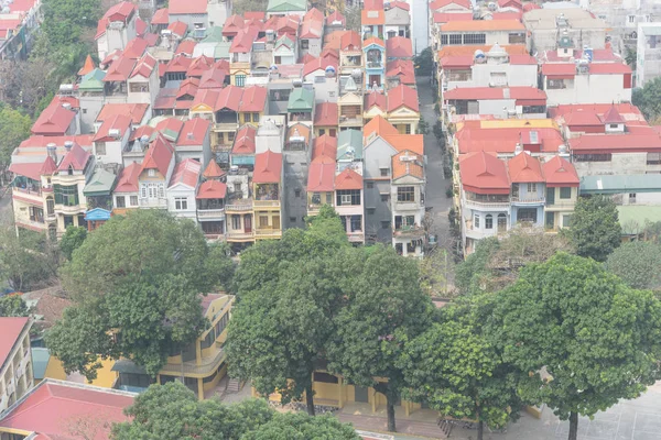 Close-up aerial view residential neighborhood near downtown Hanoi, Vietnam with dense of multistory house with red metal roof. Typical suburb house with small alley and compact lot size.