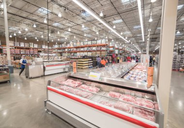 OCT 19, 2018-TEXAS, USA: Meat department and sample stand at Costco, large aisle of cooler with full of pork, beef, chicken and seafood. Customer shopping at wholesale retailer