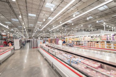 OCT 19, 2018-TEXAS, USA: Meat department at Costco, large aisle of cooler with full of pork, beef, chicken and seafood. Customer shopping at wholesale retailer
