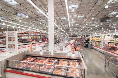 OCT 19, 2018-TEXAS, USA: Close-up pork ribs in cooler at Costco meat department. Large aisle with full of beef, chicken and seafood. Customer shopping at wholesale retailer, employee stocking goods