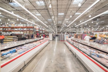 OCT 19, 2018-TEXAS, USA: Meat department at Costco, large aisle of cooler with full of pork, beef, chicken and seafood. Customer shopping at wholesale retailer