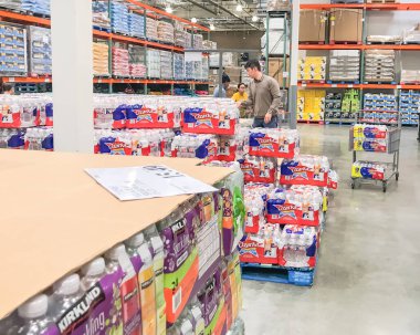 Müşteriler Costcow Deposu 'nda şişe su stokluyor.