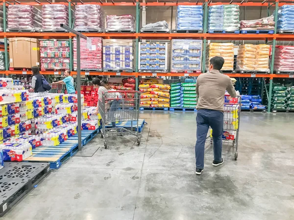 Compradores lotação de água engarrafada na loja Costcow Warehouse — Fotografia de Stock