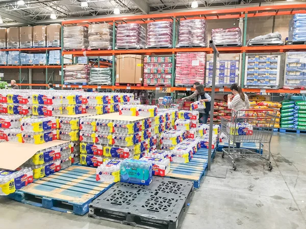 Compradores almacenando agua embotellada en la tienda Costcow Warehouse —  Fotos de Stock