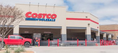 TEXAS, ABD-21 Mart 2020: Costco toptan satış mağazasının girişi Lewisville, Teksas 'ta bulutlu mavi gökyüzünde. Coronavirus salgını sırasında müşteri güvenliği için sıra sıra alışveriş arabaları sterilize edilmiştir.