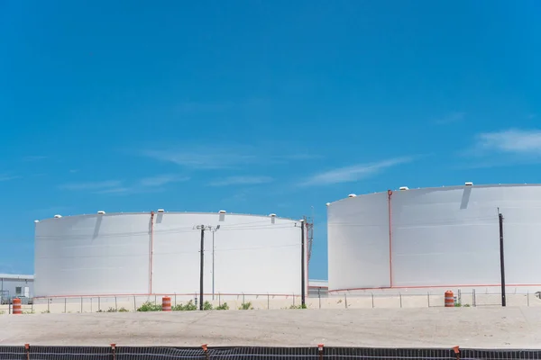 White oil storage tank with stairs under cloud blue sky in Corpus Christi, Texas, America. Large industrial container for petrol, oil, natural gas. Tank farm at petrochemical, oil refinery plant