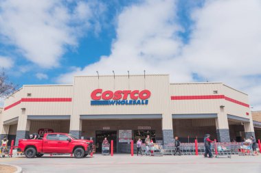 Meşgul müşteriler Lewisville, Teksas 'taki Costco toptan satış mağazasına girip çıkıyorlar.