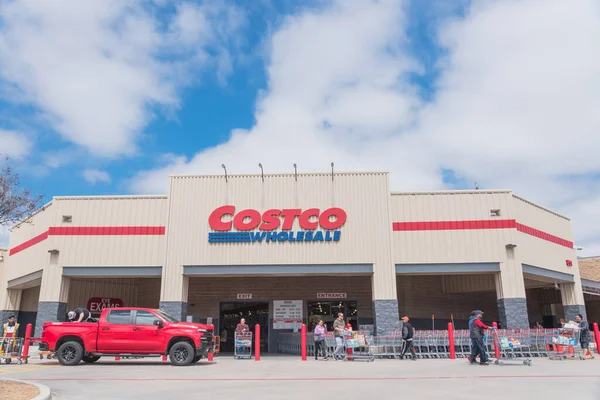 Clienti indaffarati che entrano ed escono dal negozio Costco Wholesale a Lewisville, Texas, nel cielo blu nuvola — Foto Stock