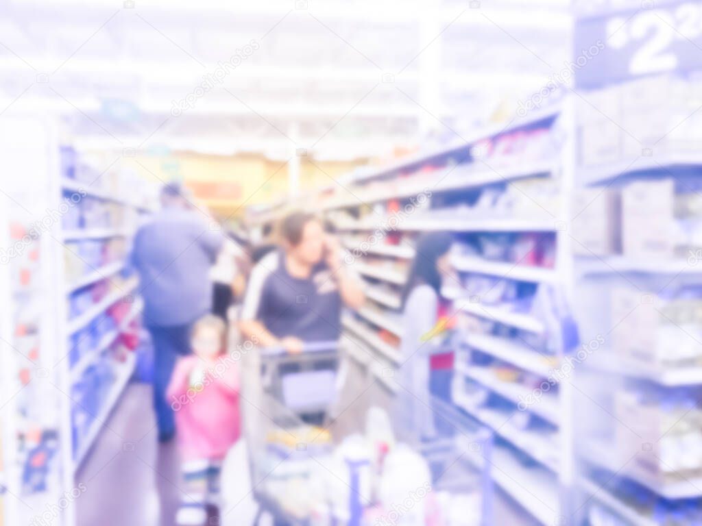 Blurry background customers with shopping cart stock up candy at grocery stores in America