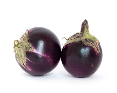 Studio shot of two organic violet round Thai eggplant isolated on white