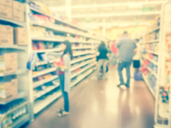 Filtered image blurry background diverse customers stock up candy at grocery stores in USA