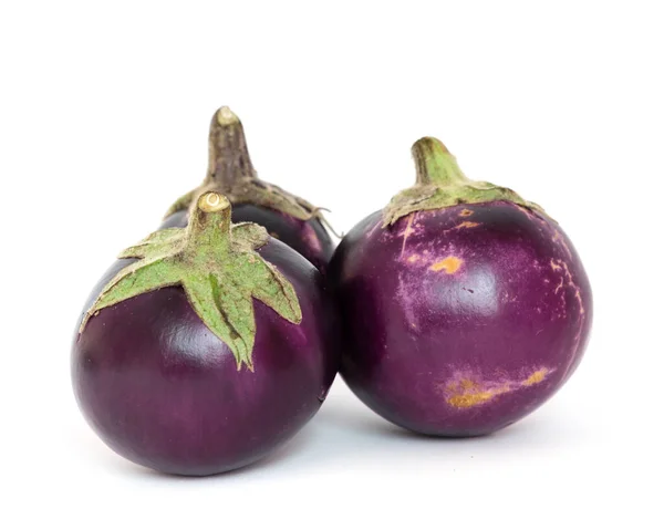 Studio shot of three organic violet round Thai eggplant isolated on white — Stok fotoğraf