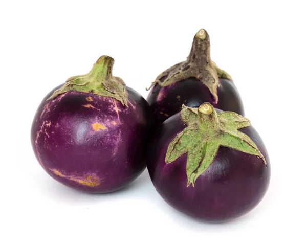 Studio shot of three organic violet round Thai eggplant isolated on white — Stok fotoğraf