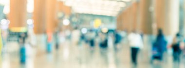 Panoramik bulanık arka plan yolcuları Singapur 'daki Changi havaalanı koridorunda yürüyorlar.