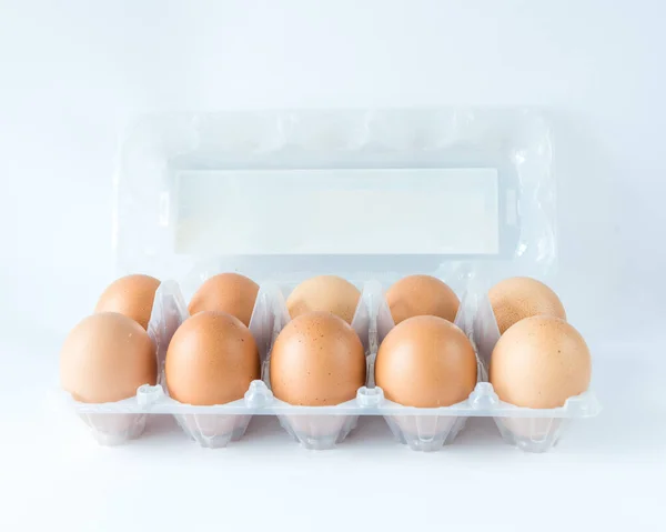 Studio sparato vassoio di plastica coperchio aperto con dieci uova di pollo allevate al pascolo isolato su bianco — Foto Stock