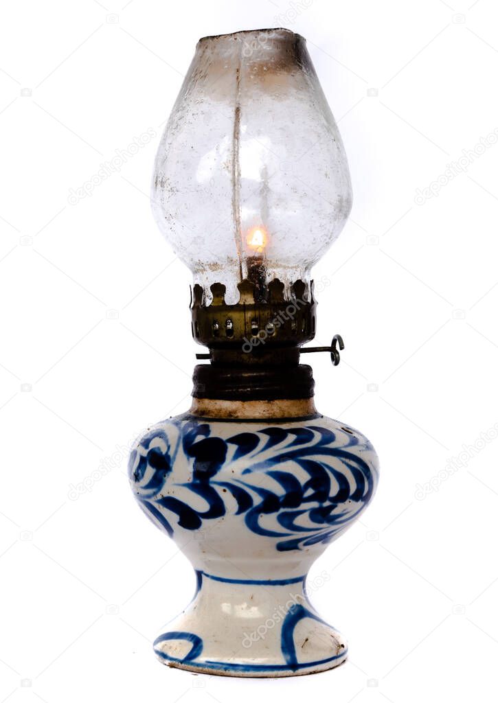 Studio shot burning light in traditional Vietnamese oil lamp isolated on white