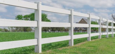 Ennis, Teksas, ABD 'deki tarım arazilerinde bulut mavisi gökyüzünde uzanan panoramik uzun tahta beyaz çit.